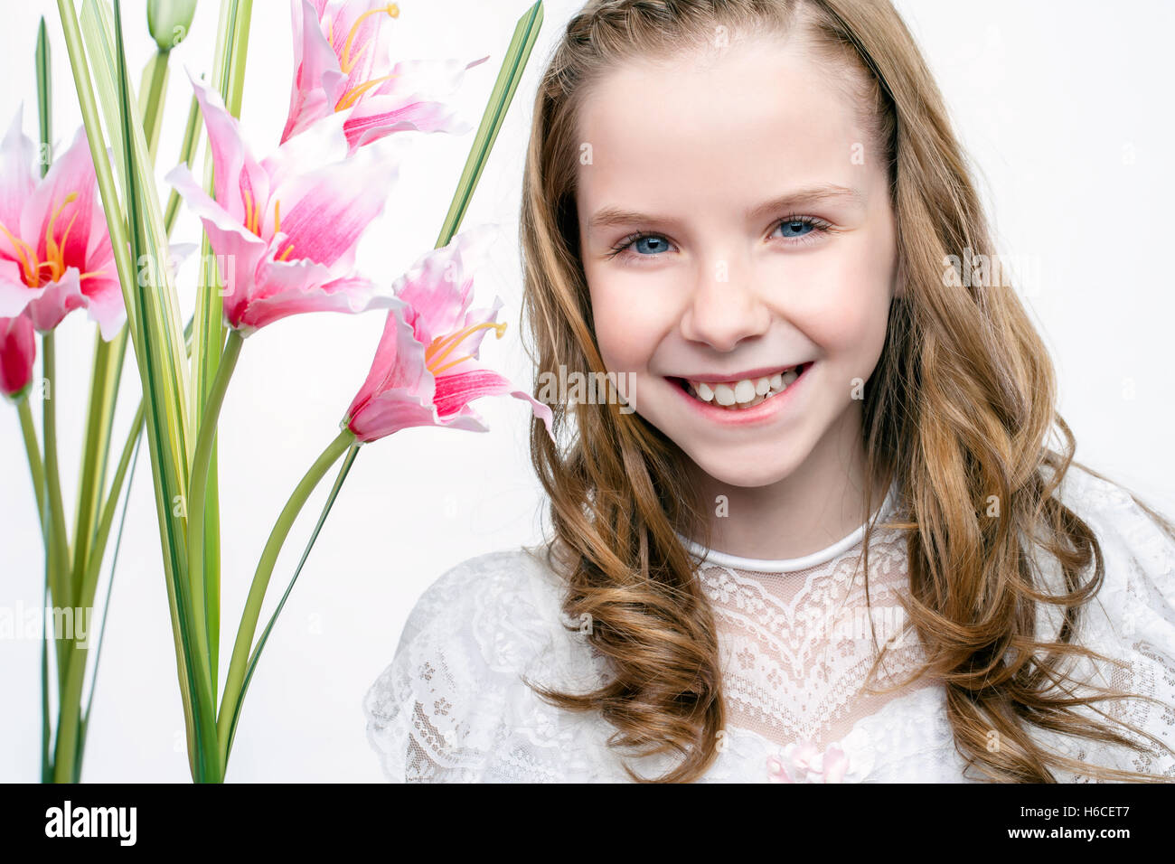 Hautnah Beauty Studioportrait von niedlichen Kommunion Mädchen mit Blumen. Stockfoto