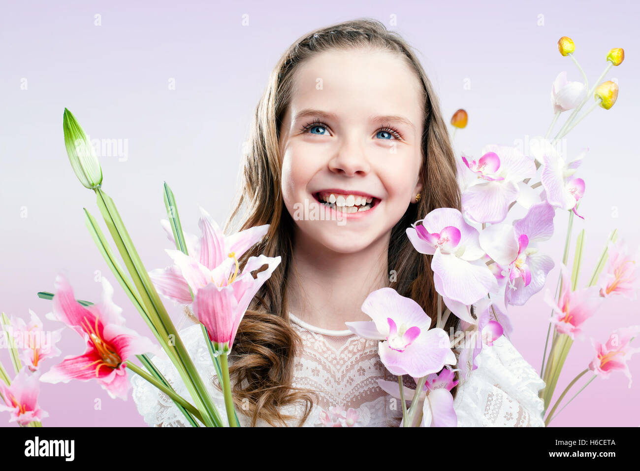 Großaufnahme Spaß Porträt Kommunion Mädchen mit bunten Blumen. Stockfoto