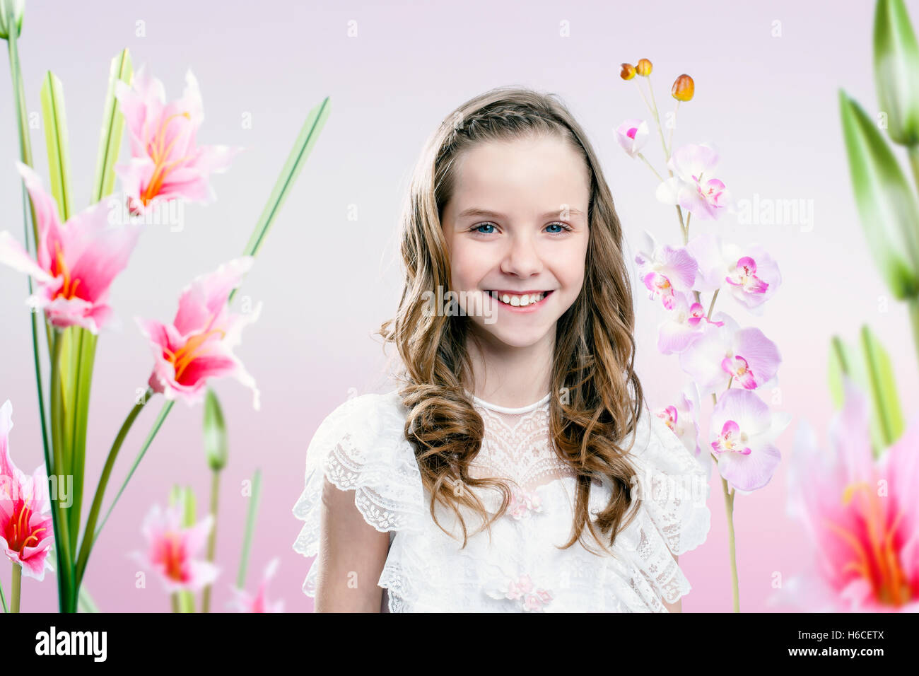 Porträt des jungen Mädchens Kommunion Kleid im Blumengarten hautnah. Stockfoto