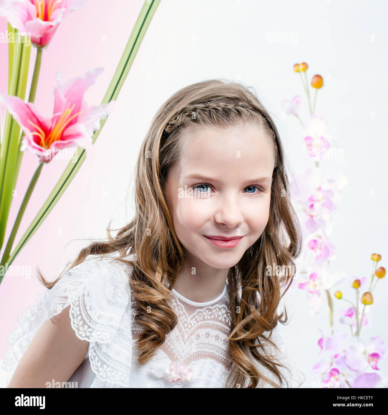 Hautnah Beauty Portrait von junge Mädchen in weißen Kommunion Kleid unter Blumen. Stockfoto
