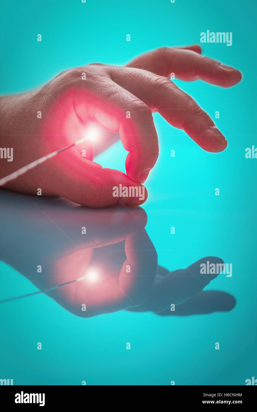 Helles Licht Quelle am Ende der Sonde zwischen groß und index Finger der linken Hand die person Stockfoto