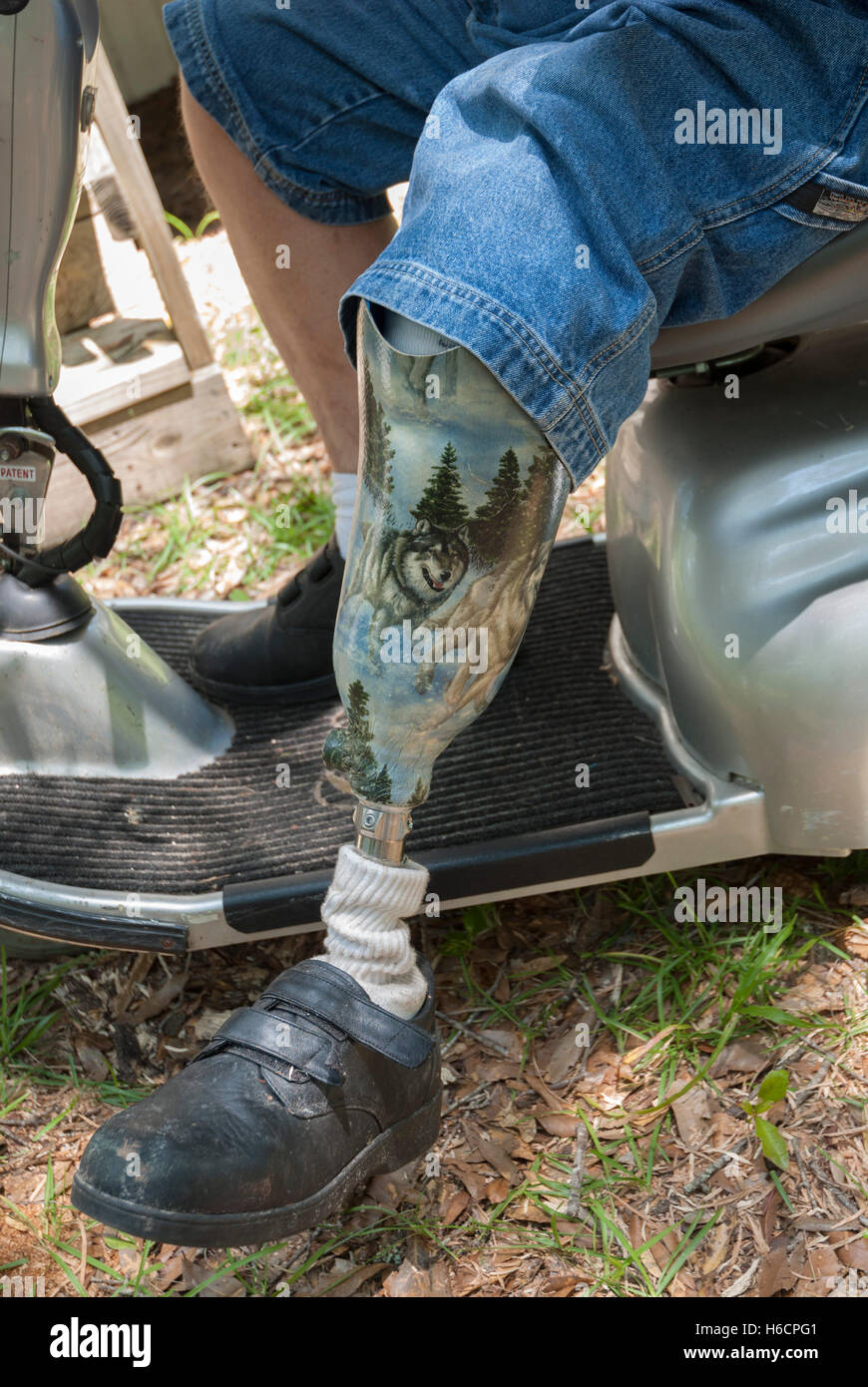 Beinprothese mit gemalten Szene auf einer Amputierten. Stockfoto