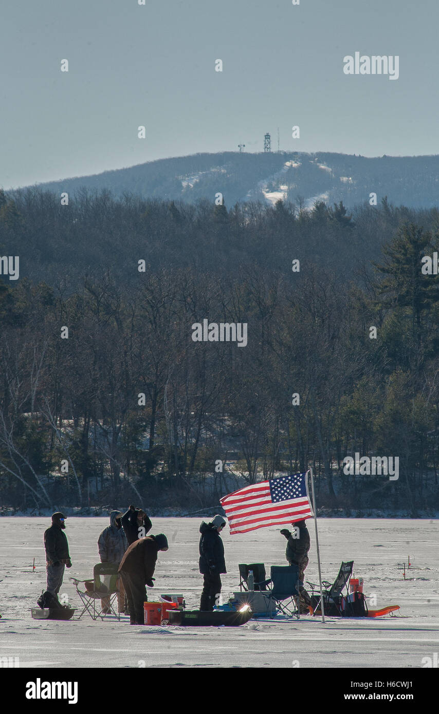 Eis-Fischer fliegen eine amerikanische Flagge auf runden Teich, Wiese an einem bitter kalten Morgen im Schatten des Wachusett Mt, Westminster Masse Stockfoto
