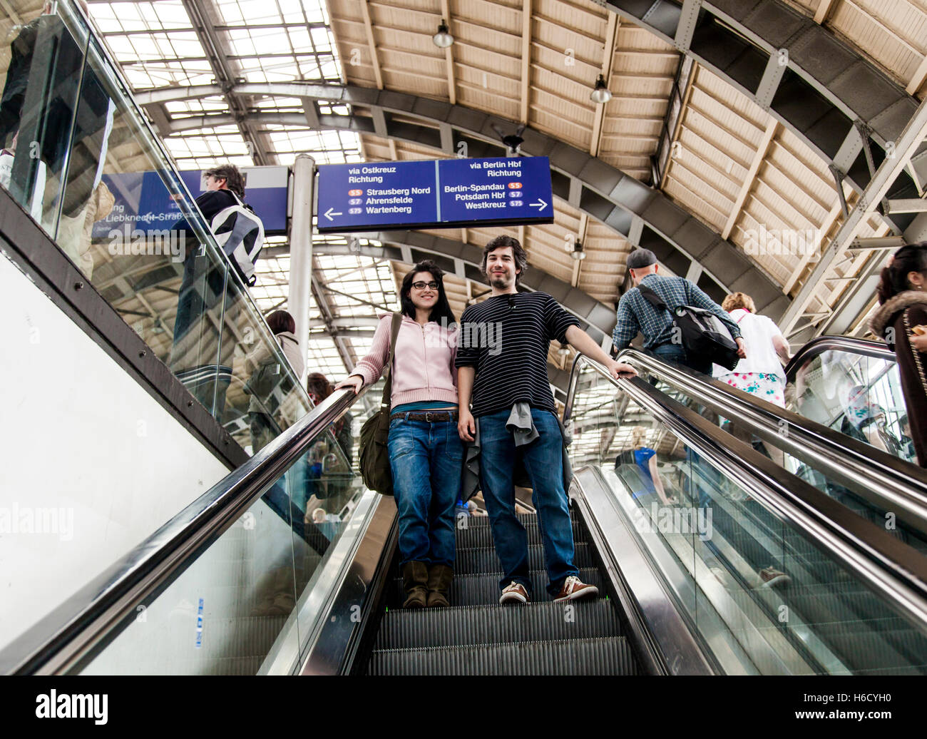 Paar Anfang 30 lächelnd in die Kamera beim Abstieg eine Rolltreppe aus dem Bahnsteig in der Alexanderpla Stockfoto