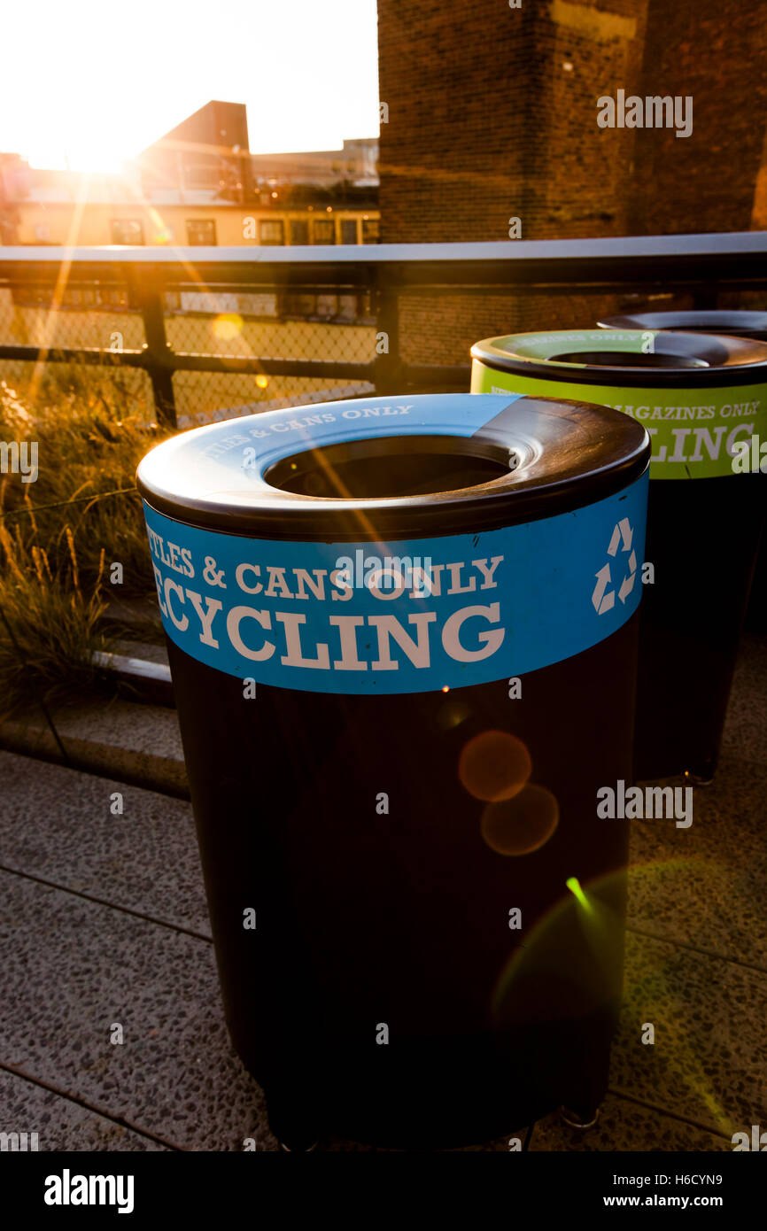 Niedrige Nachmittagssonne hinter drei recycling-Behälter in der Highline Park in Manhattan, blau für Flaschen & Dosen, grün für Papier und bl Stockfoto