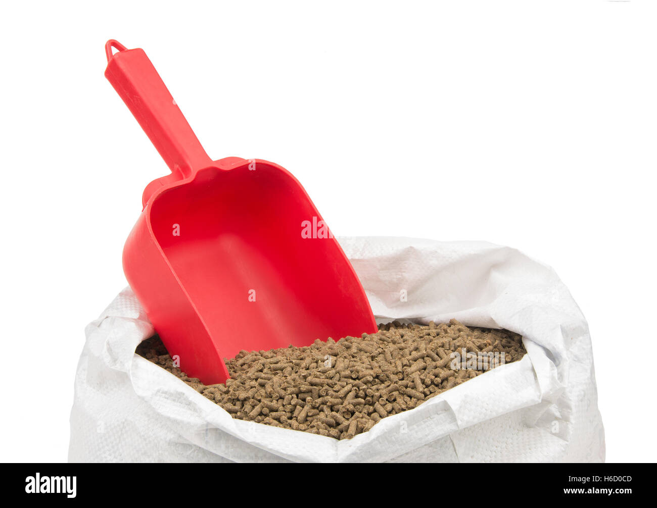 Rote standard Schaufel für die Messung von Pferdefutter, stehend in pelleted Futtermittel, isoliert auf weiß Stockfoto