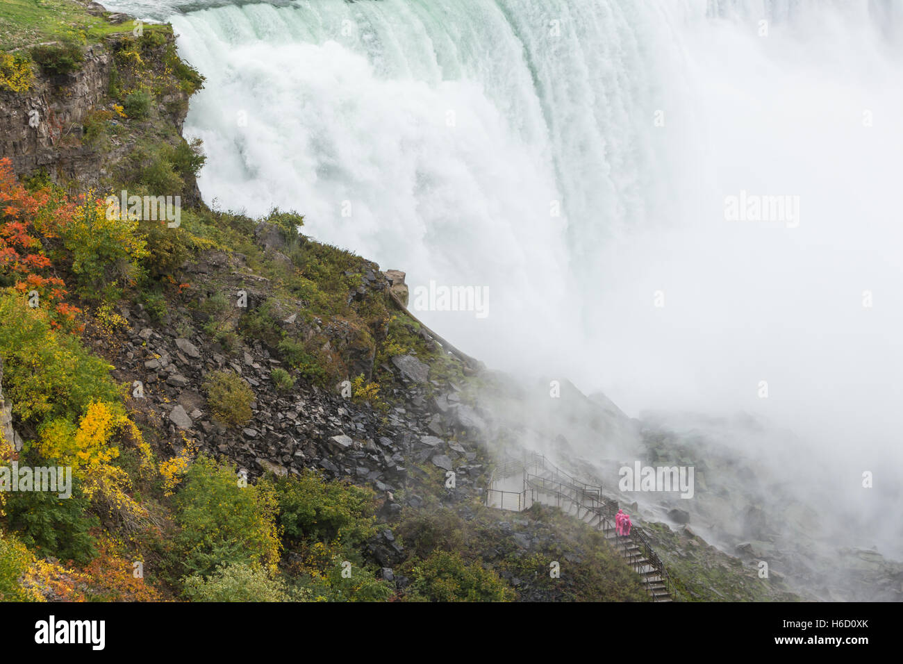 Menschen in Regenponchos trotzen dem Nebel und Spray von der amerikanischen Wasserfälle auf dem Weg zum Crows Nest in Niagara Falls, New York Stockfoto