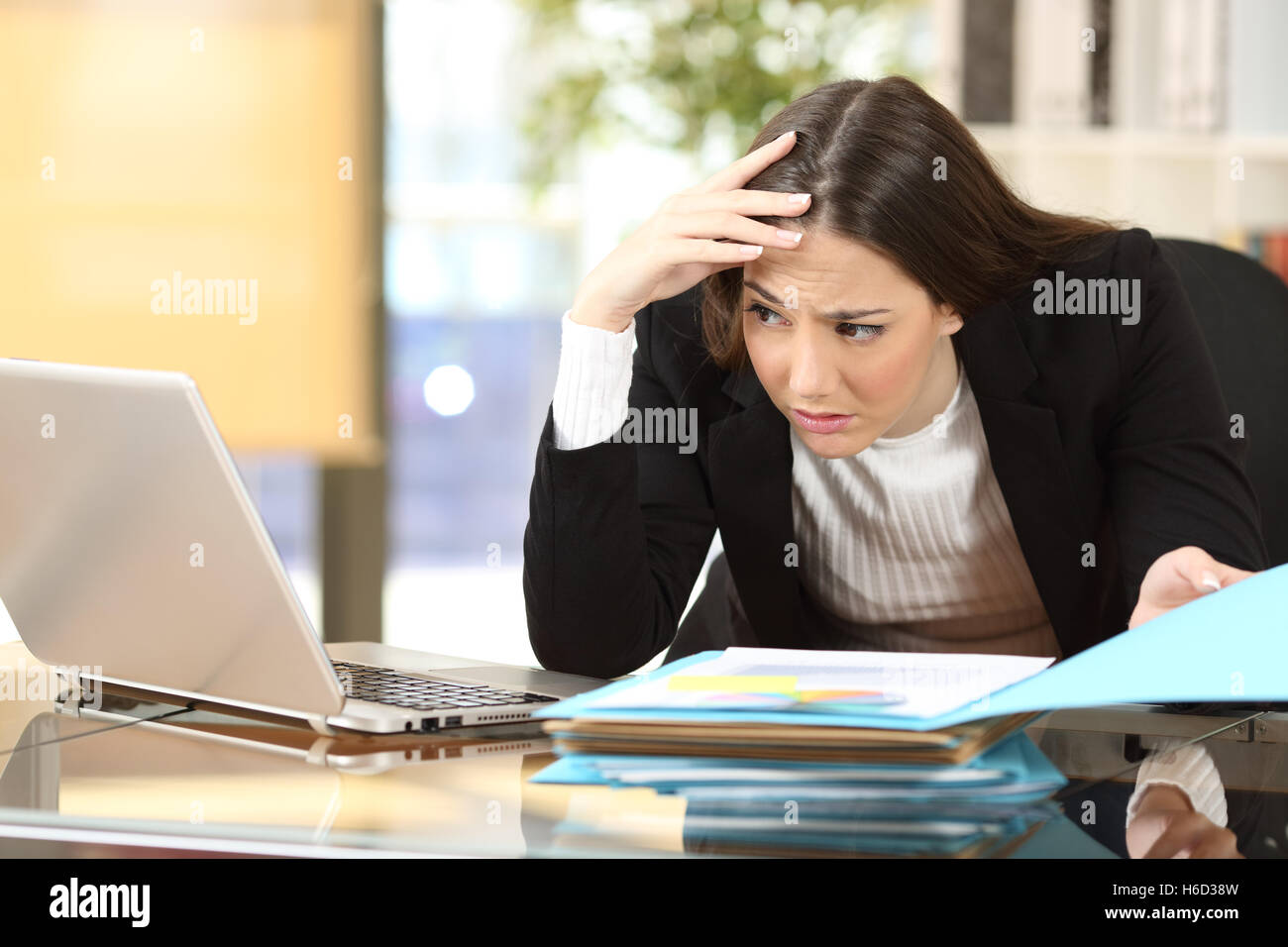 Besorgt Geschäftsfrau mit eine schwierige Aufgabe, die gerade ihren Laptop auf Linie in einem Schreibtisch im Büro Stockfoto