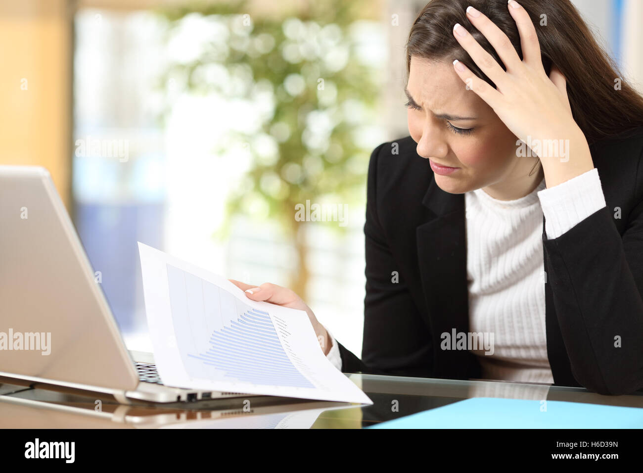 Besorgt Geschäftsfrau in Konkurs gerade verringerte Verkaufsstatistiken in ein Dokument in Papierform im Büro Stockfoto