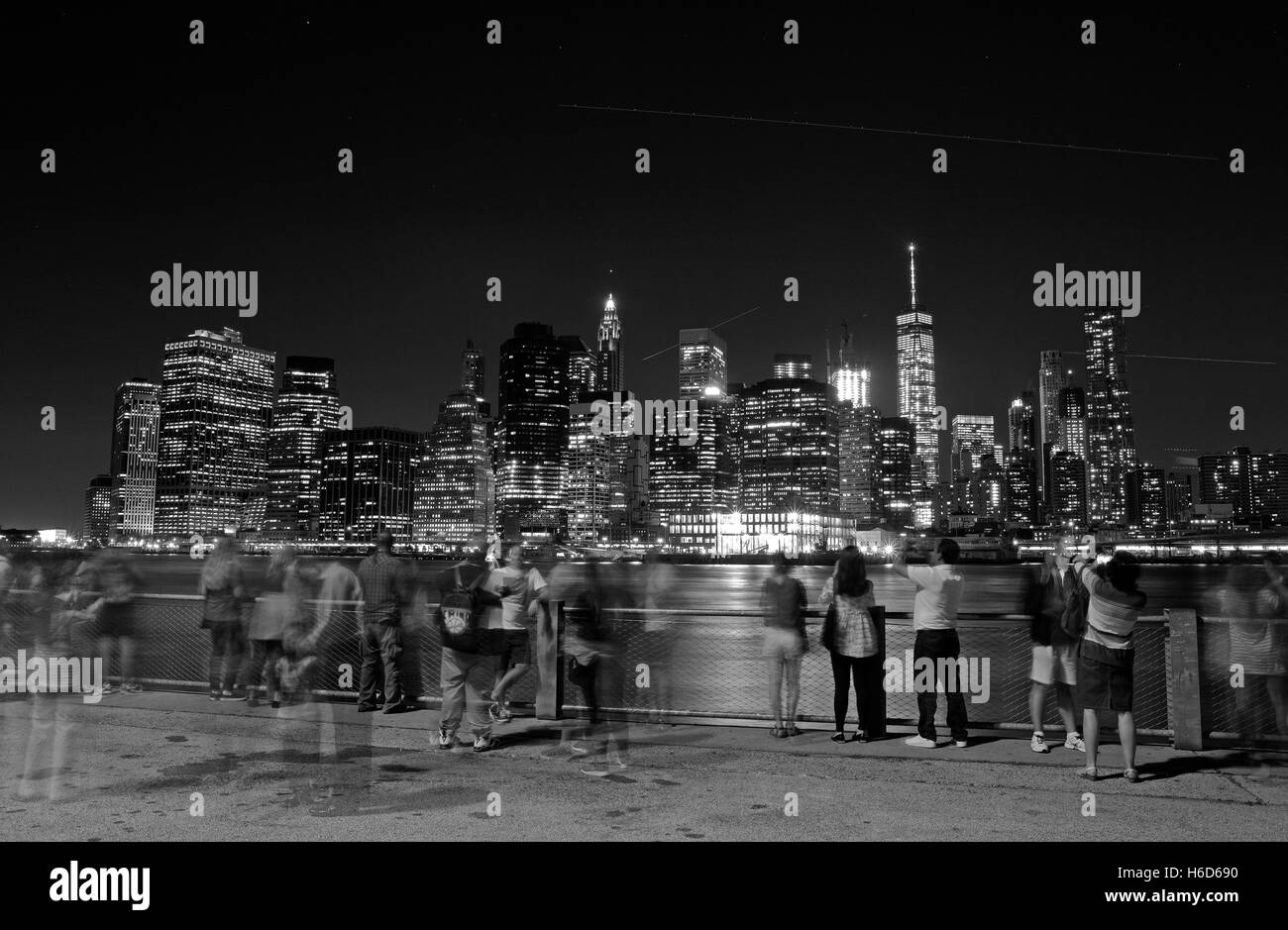 Menschen versammeln, um die Zeit Nachtansicht von lower Manhattan über den East River aus Brooklyn, NY, Vereinigte Staaten von Amerika zu bewundern. B&W Bild Stockfoto