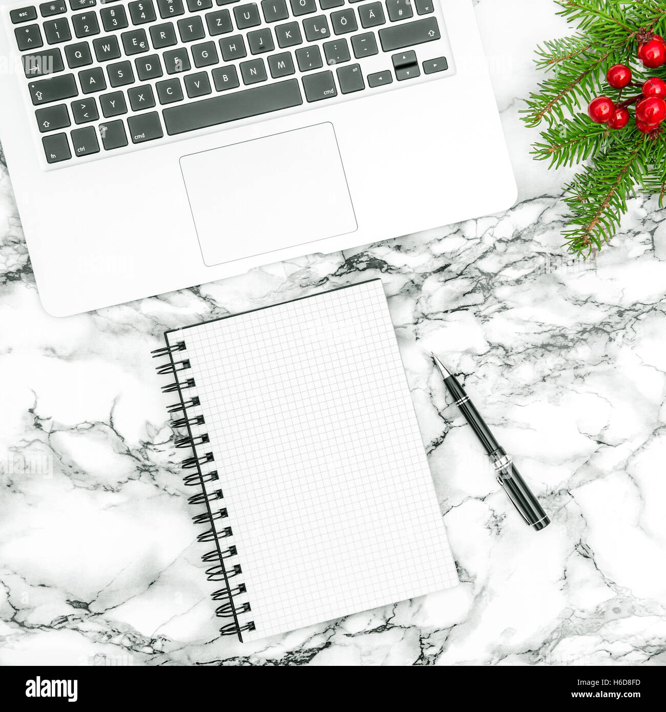 Schreibtisch mit Weihnachtsdekoration. Aufgeschlagene Buch und Stift auf Marmor Hintergrund Stockfoto