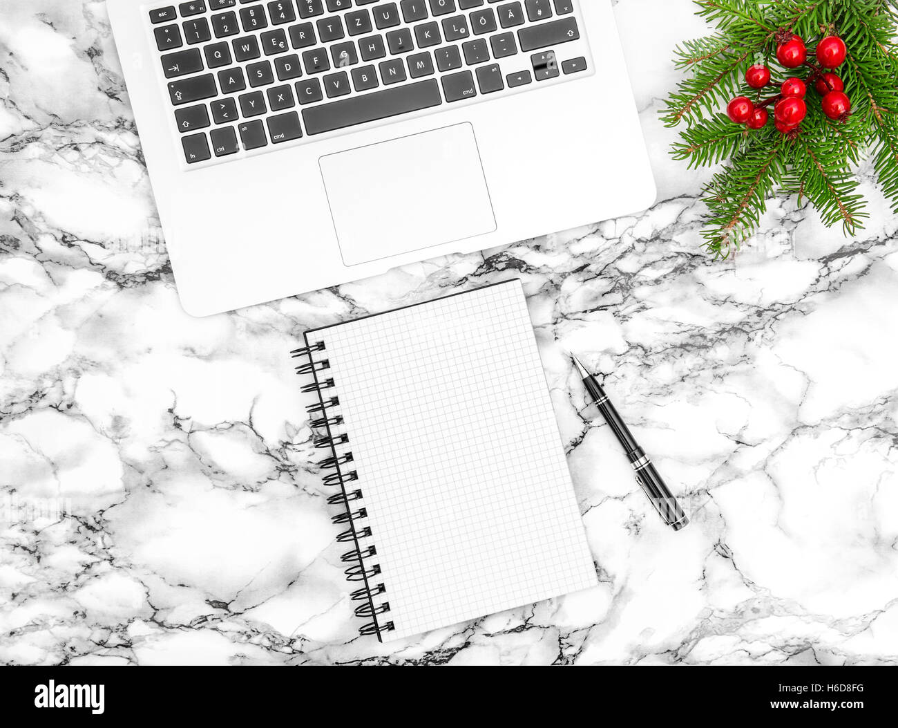 Schreibtisch mit Weihnachtsdekoration. Papierbuch offen und Stift. Business-Reisen-Konzept Stockfoto