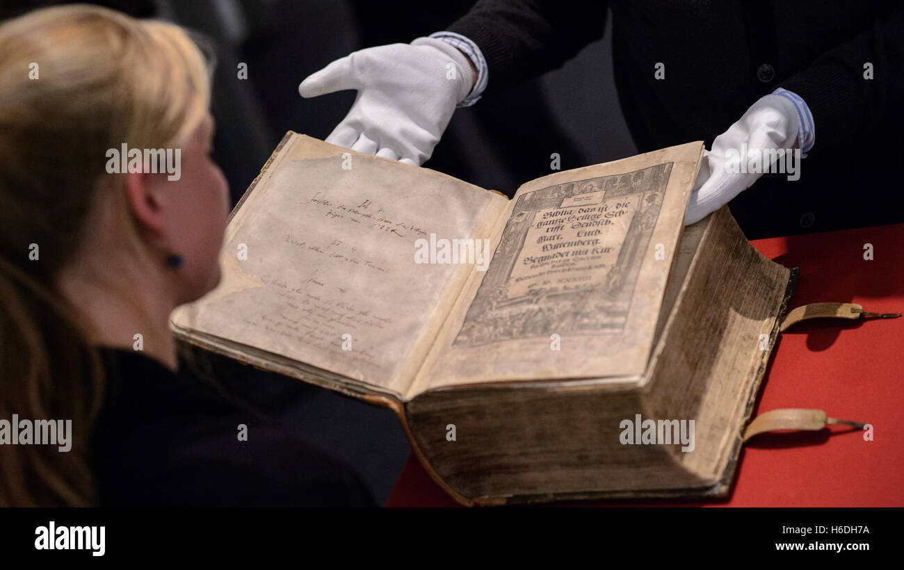 Eine Frau betrachten die Bibel von der Familie von Martin Luther mit seiner eigenen Handschrift während der Vorschau der Ausstellung "Wissensspeicher der Reformation" (lit.) "Wissensspeicherung der Reformation") an den Frankeschen Stiftungen in Halle/Saale, Deutschland, 27. Oktober 2016. Foto: JENS SCHLUETER/dpa Stockfoto