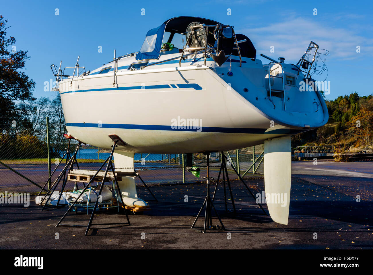 Segelboot auf Stelzen umzäunten Außenbereich im Hafen im Herbst. Stockfoto