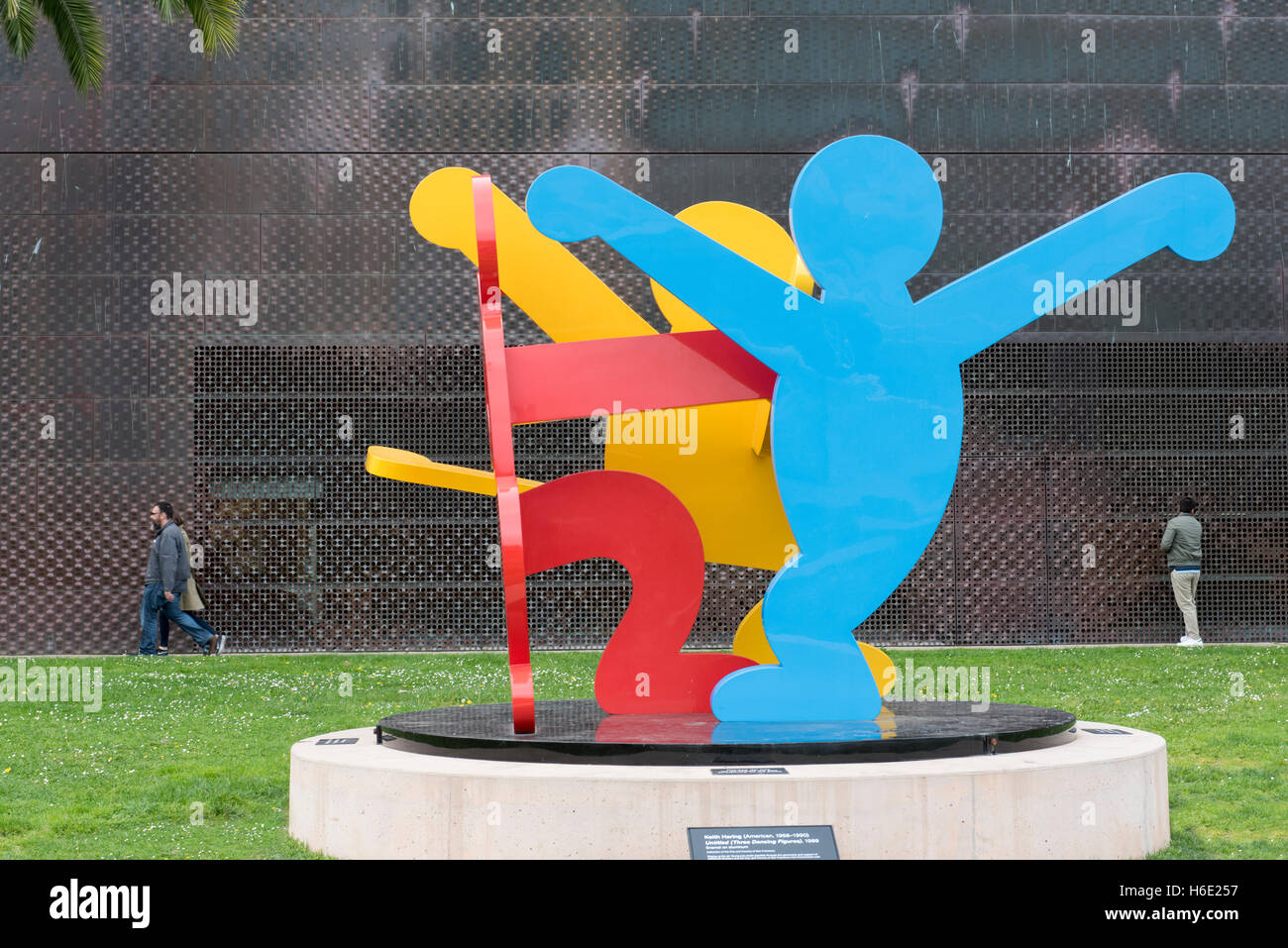 Skulptur (drei tanzende Figuren von Keith Haring) mit das de Young Museum und die Kunstgalerie im Hintergrund, San Francisco, USA Stockfoto