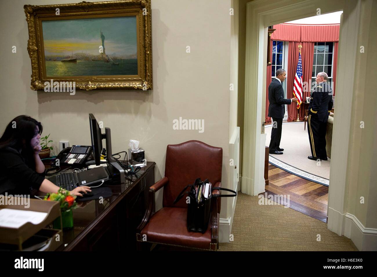 US-Präsident Barack Obama spricht mit Joint Chiefs Of Staff Vorsitzender Martin Dempsey Oval Office im Weißen Haus als Präsidenten persönlicher Adjutant Ferial Govashiri an ihrem Schreibtisch in die äußere Oval Office 11. März 2015 in Washington, DC arbeitet. Stockfoto