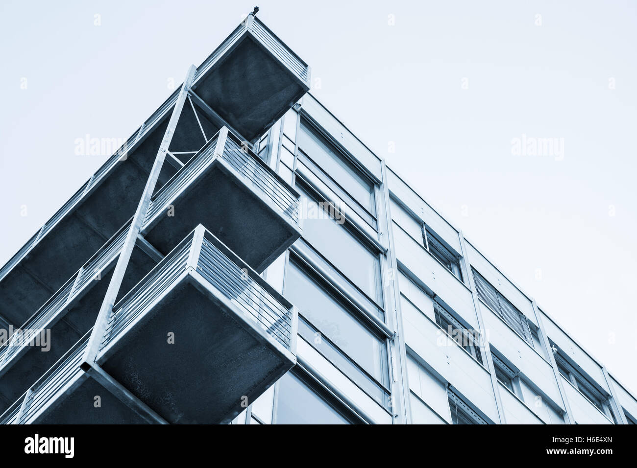 Abstrakte zeitgenössische Architektur Fragment, Wände und Balkone aus Glas und Beton hergestellt. Blaue Tonwertkorrektur Filter Foto Stockfoto