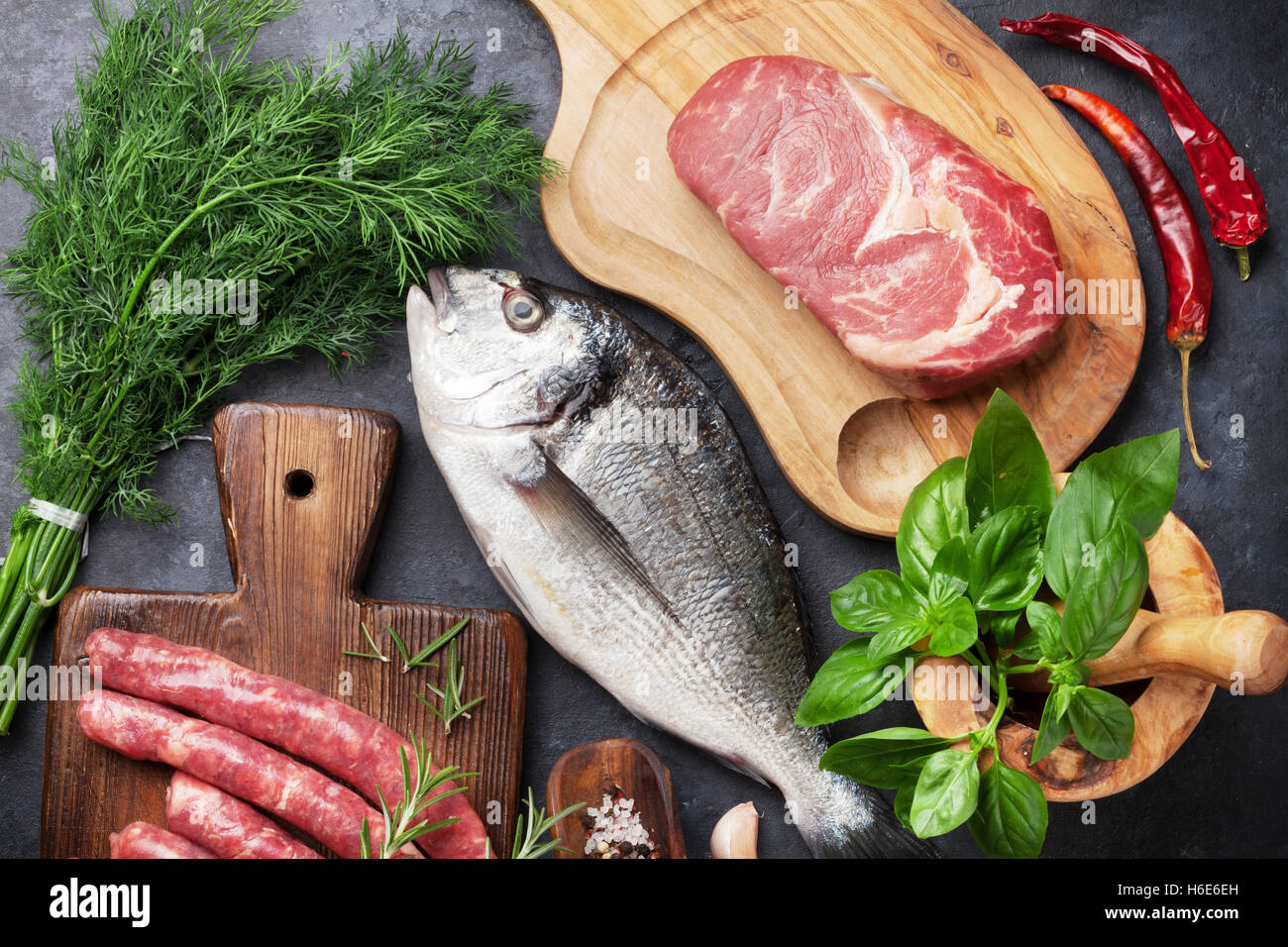 Wurst, Fisch, Fleisch und Zutaten kochen. Draufsicht auf Steintisch Stockfoto