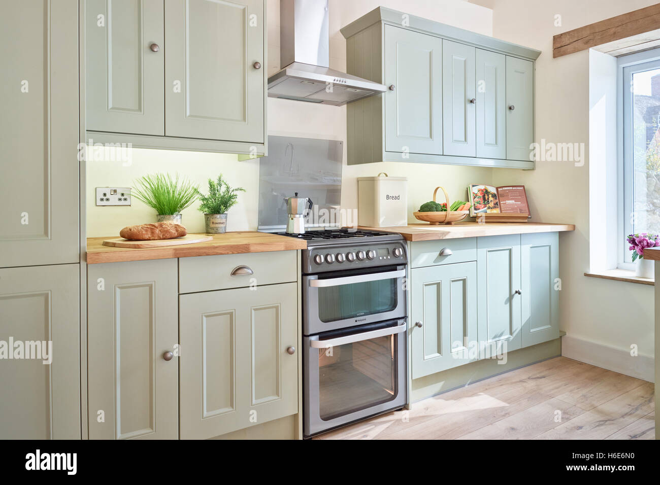 Eine moderne, frische offene Küche mit integriertem Backofen, Arbeitsplatten Herd, Dunstabzugshaube & Holz. Oxfordshire, Vereinigtes Königreich Stockfoto