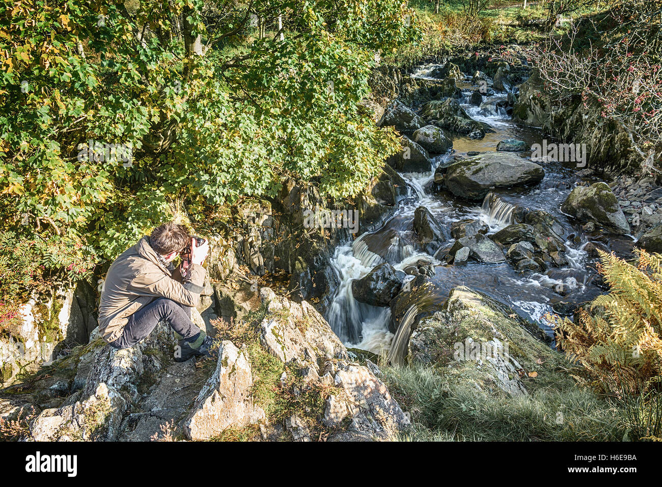 Junge männliche Fotograf bei Watendlath fällt, Cumbria, UK. Stockfoto