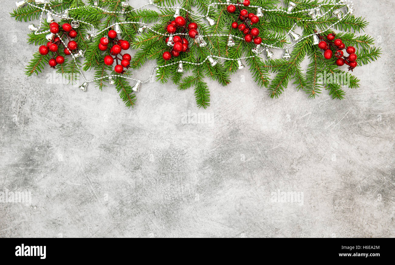 Weihnachtsbaum-Zweige mit roten Beeren und silbernen Kranz. Urlaub Dekoration Stockfoto