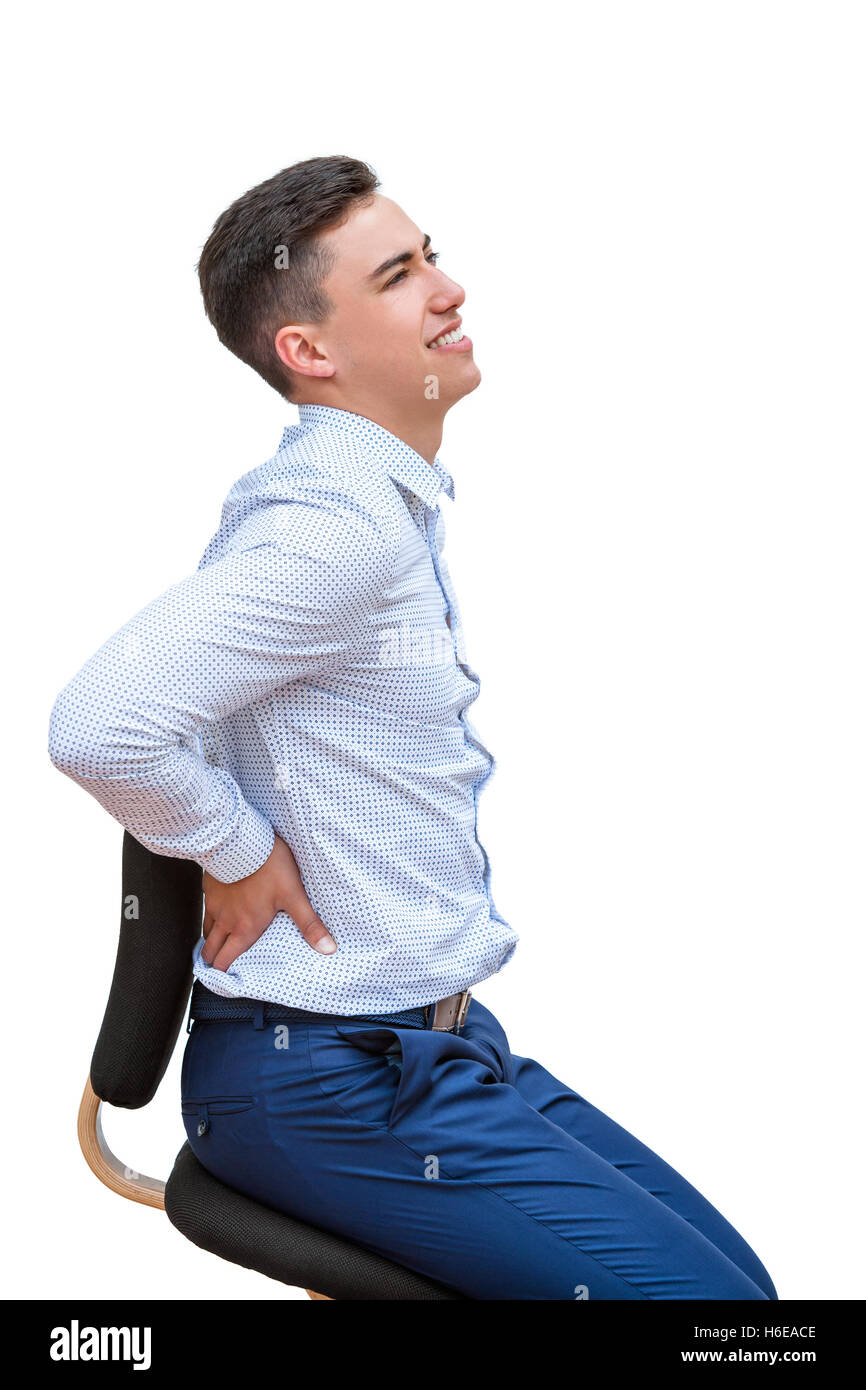 Porträt des jungen Büroangestellten, dass Symptom von Schmerzen im unteren Rückenbereich hautnah. Junger Mann sitzen auf ergonomischen Stuhl isoliert Stockfoto