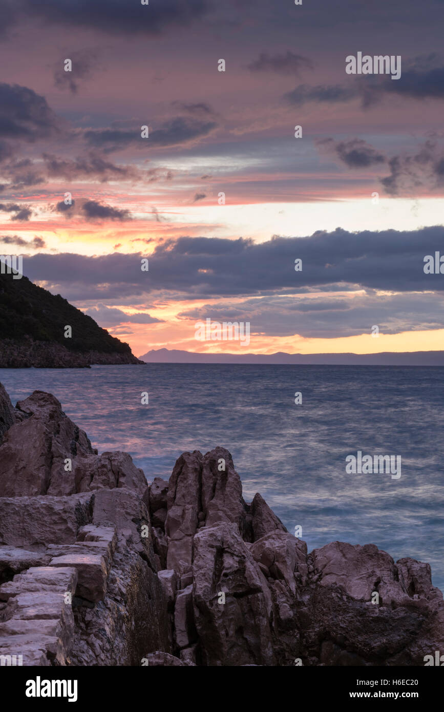 Sonnenuntergang und einem lila Himmel über der Adria in Trpanj Kroatien mit einer Langzeitbelichtung und Motion blur auf dem Wasser Stockfoto
