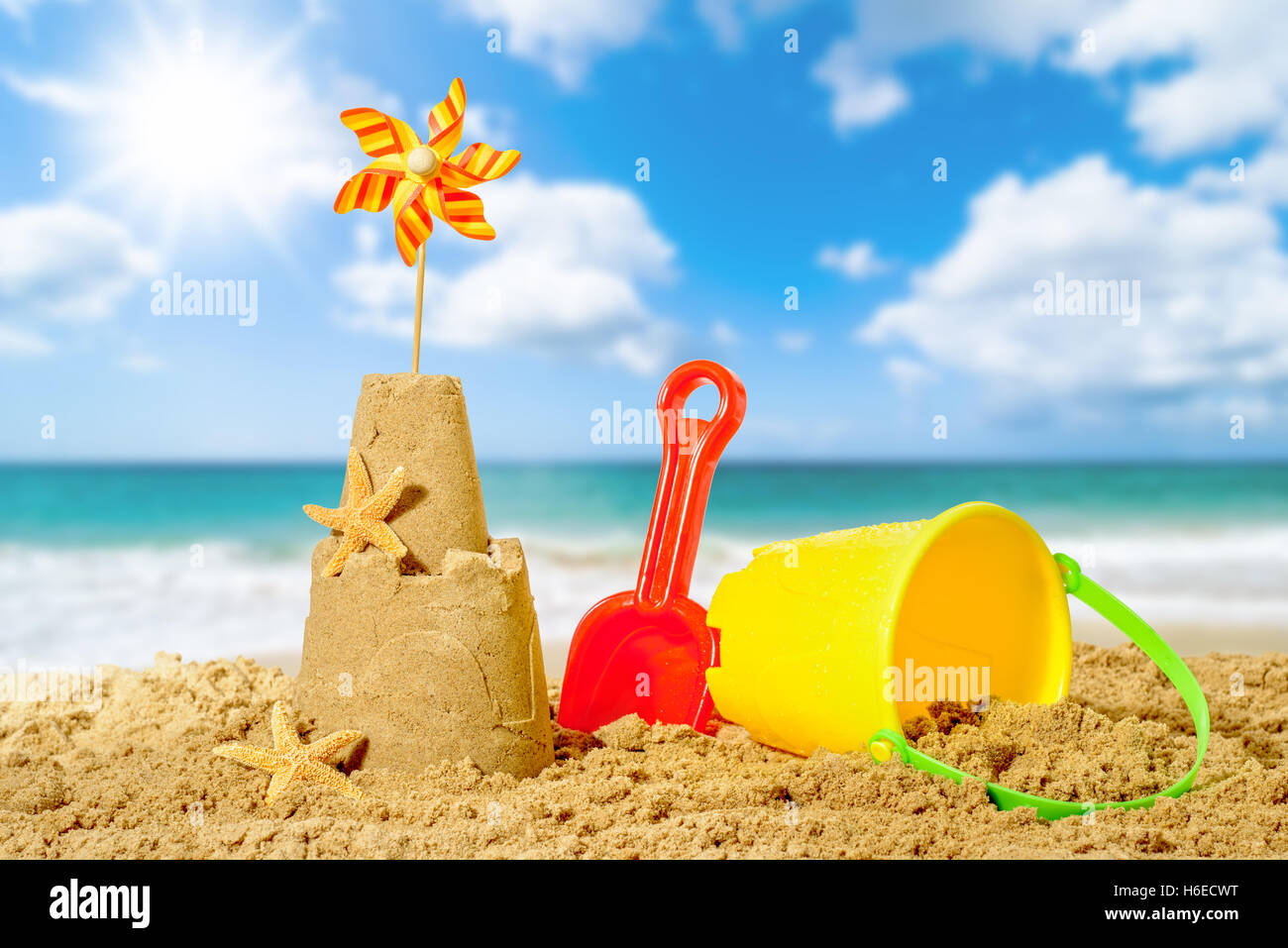 Sandburg mit Eimer und Spaten mit Strand Weichzeichnen Hintergrund Stockfoto