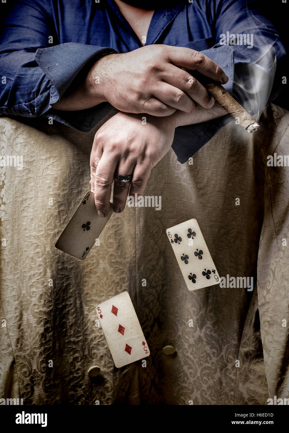 Mann, raucht eine Zigarre und Pokern mit fallenden Karten Stockfoto