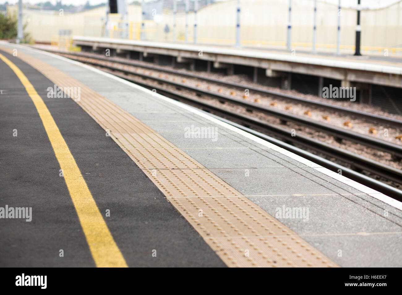Gelbe Linie und Rumble Strips auf einem Bahnsteig in England UK Stockfoto