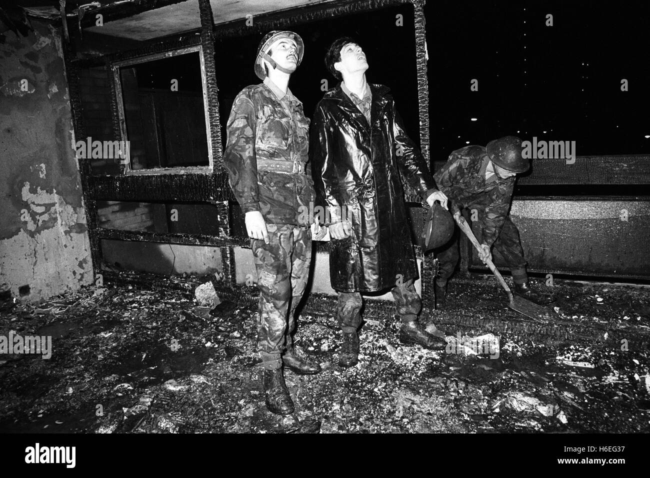 Soldaten von Chelsea Barracks inspizieren die verbrannten, Ruinen einer drei-Zimmer-Maisonette in Westbridge Road, London. Eine Mutter und ihre zwei Kinder unverletzt. Stockfoto