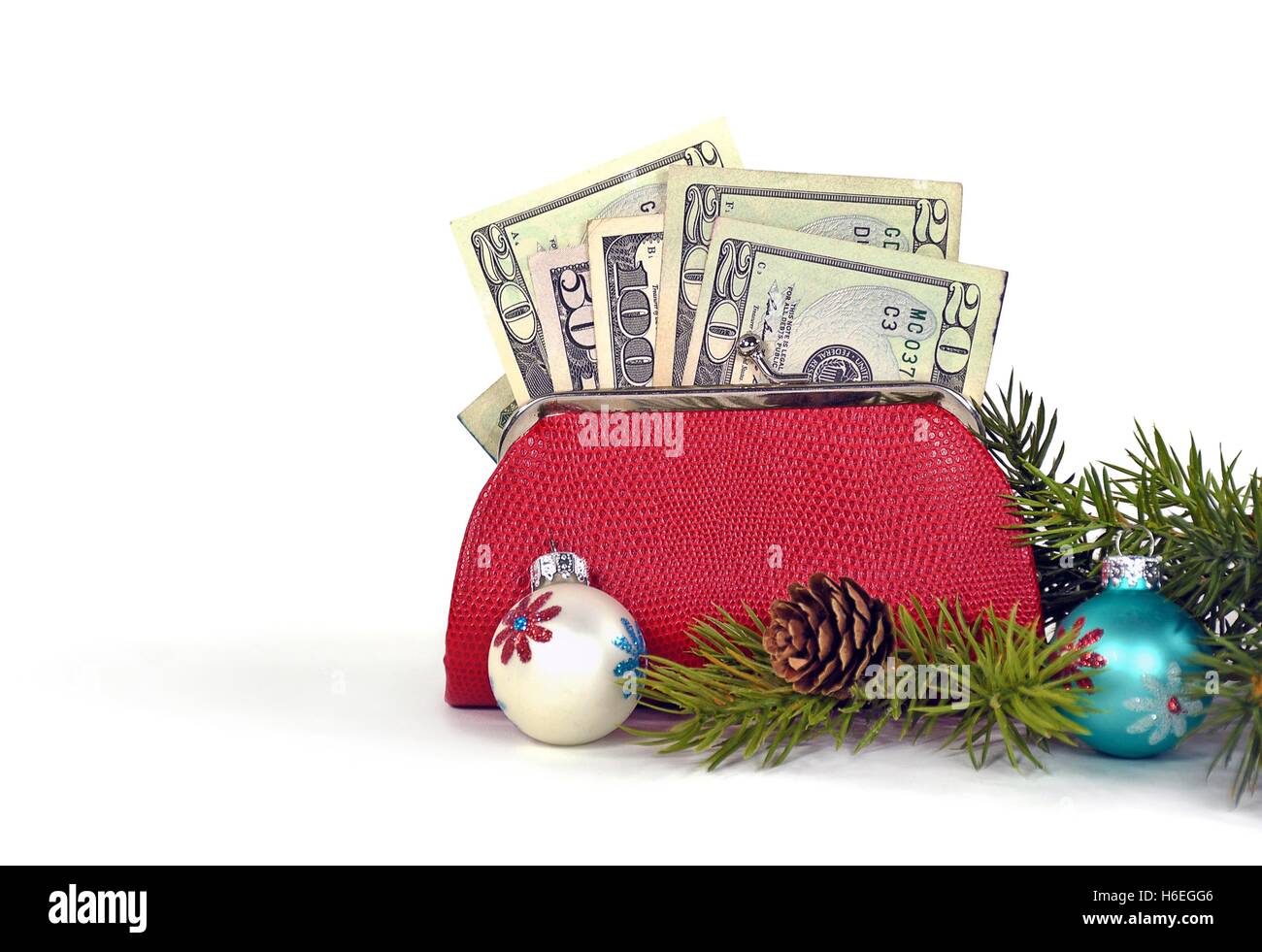 Geld in Rot ändern/Geldbörse mit Weihnachtsschmuck und Kiefer auf weiß Stockfoto