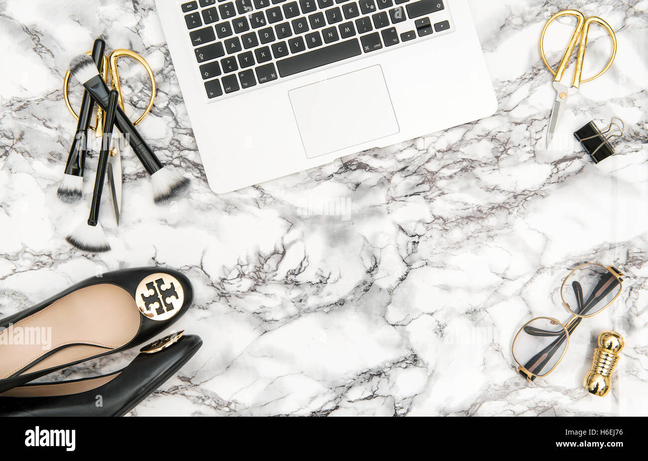 Notebook, Schuhe, Bürobedarf, feminine Accessoires auf hellen Marmortisch Hintergrund. Mode flach legen für Blogger social mich Stockfoto