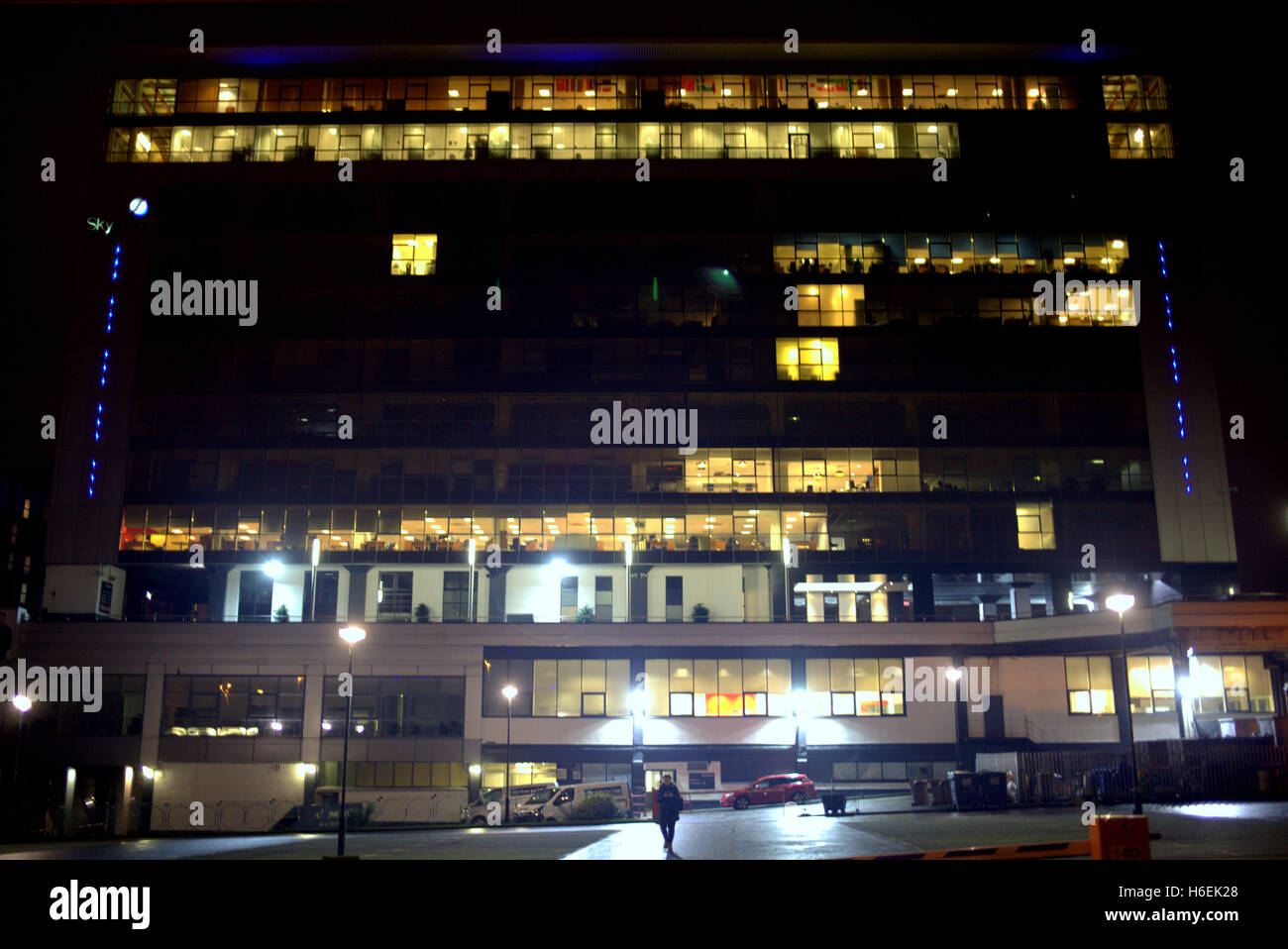 einzelne Mensch zu Fuß entfernt von beleuchteten Skypark Finnieston Glasgow Büro-Hochhaus in der Nacht Stockfoto