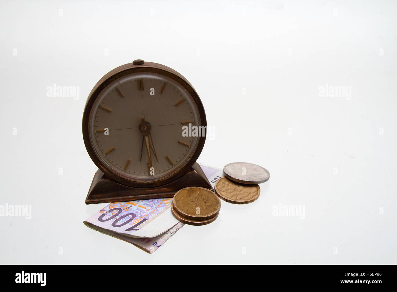 Eine Uhr und etwas Bargeld auf einer freien Oberfläche Bild im Querformat mit Kopie Raum isoliert Stockfoto