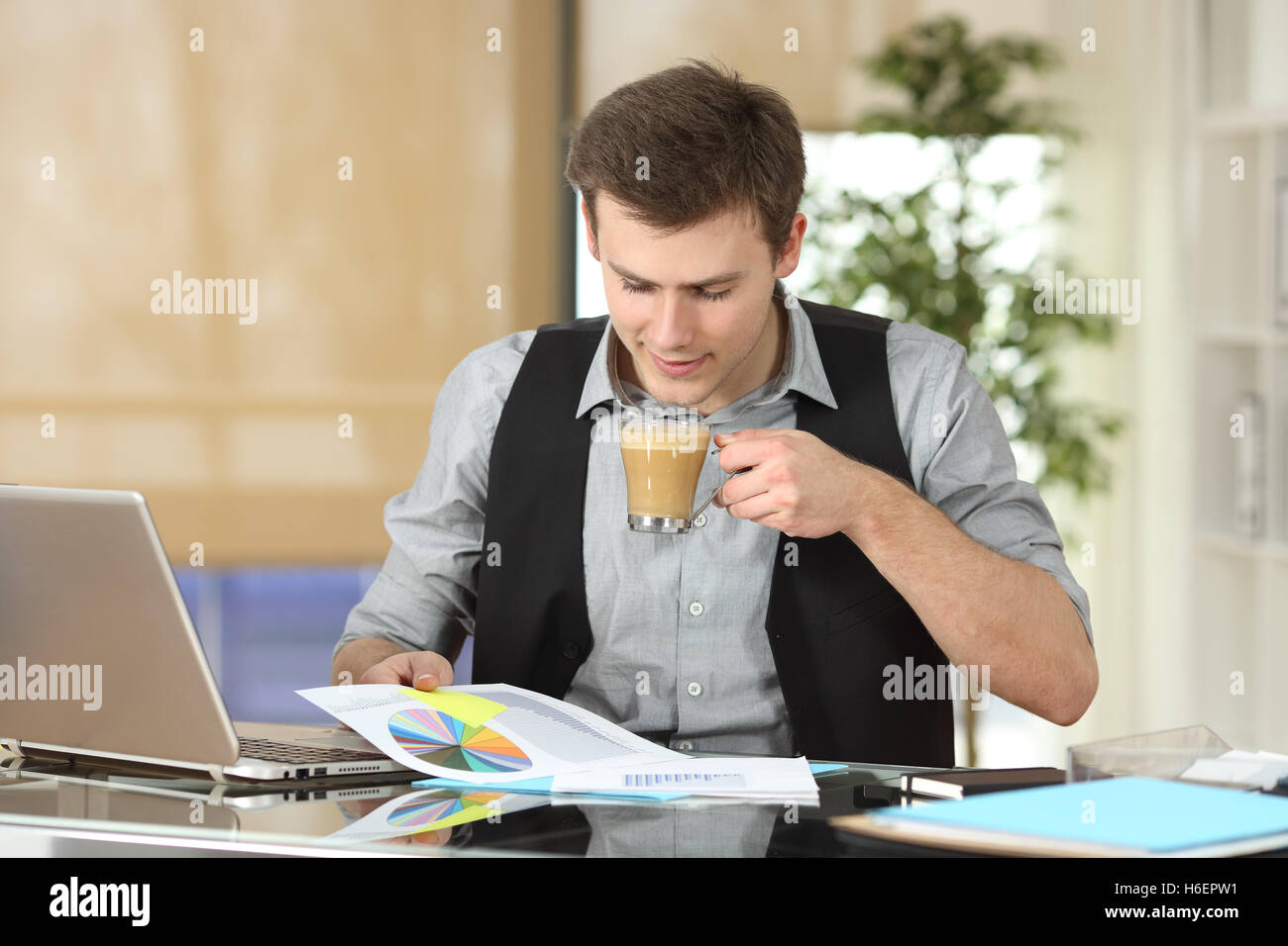 Geschäftsmann lesen Wachstum Diagramm mit einer Tasse Kaffee im Büro Stockfoto