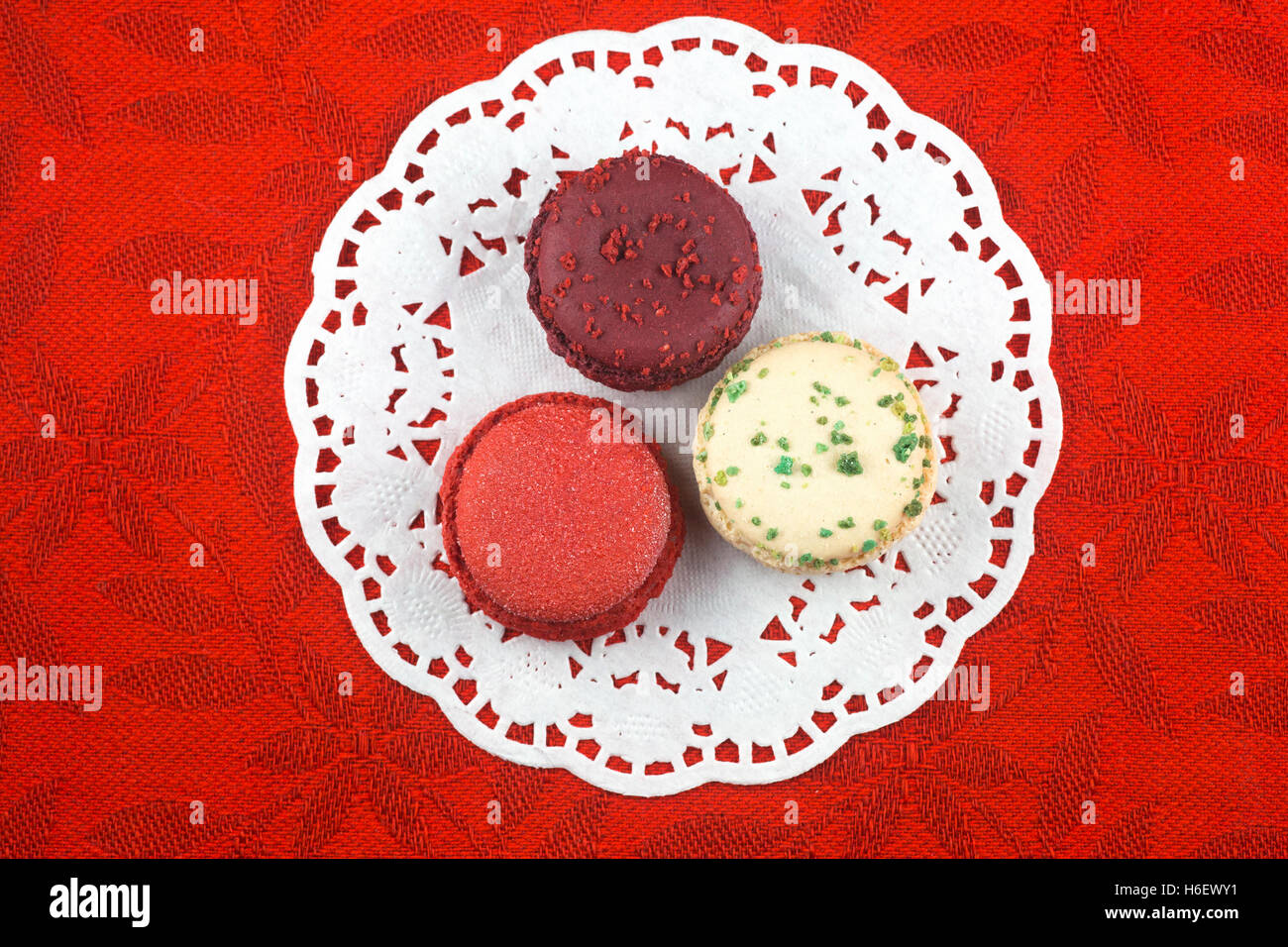 Weihnachten Macarons, Vanille, Basilikum, Matt Cranberry und Glühwein Weine Aromen auf roten Tischdecke Stockfoto