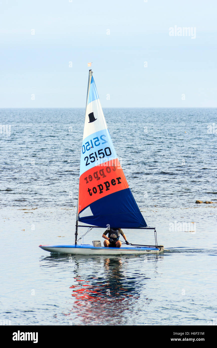 Eine einzige Segler segeln auf einem ruhigen See bei Ringstead Bay, Dorset, England, Großbritannien Stockfoto