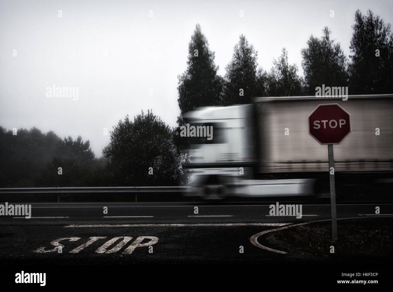 Foto von LKW, die Beschleunigung auf Straße, Stop-Schild und Stop Buchstaben gemalt in den Boden Stockfoto