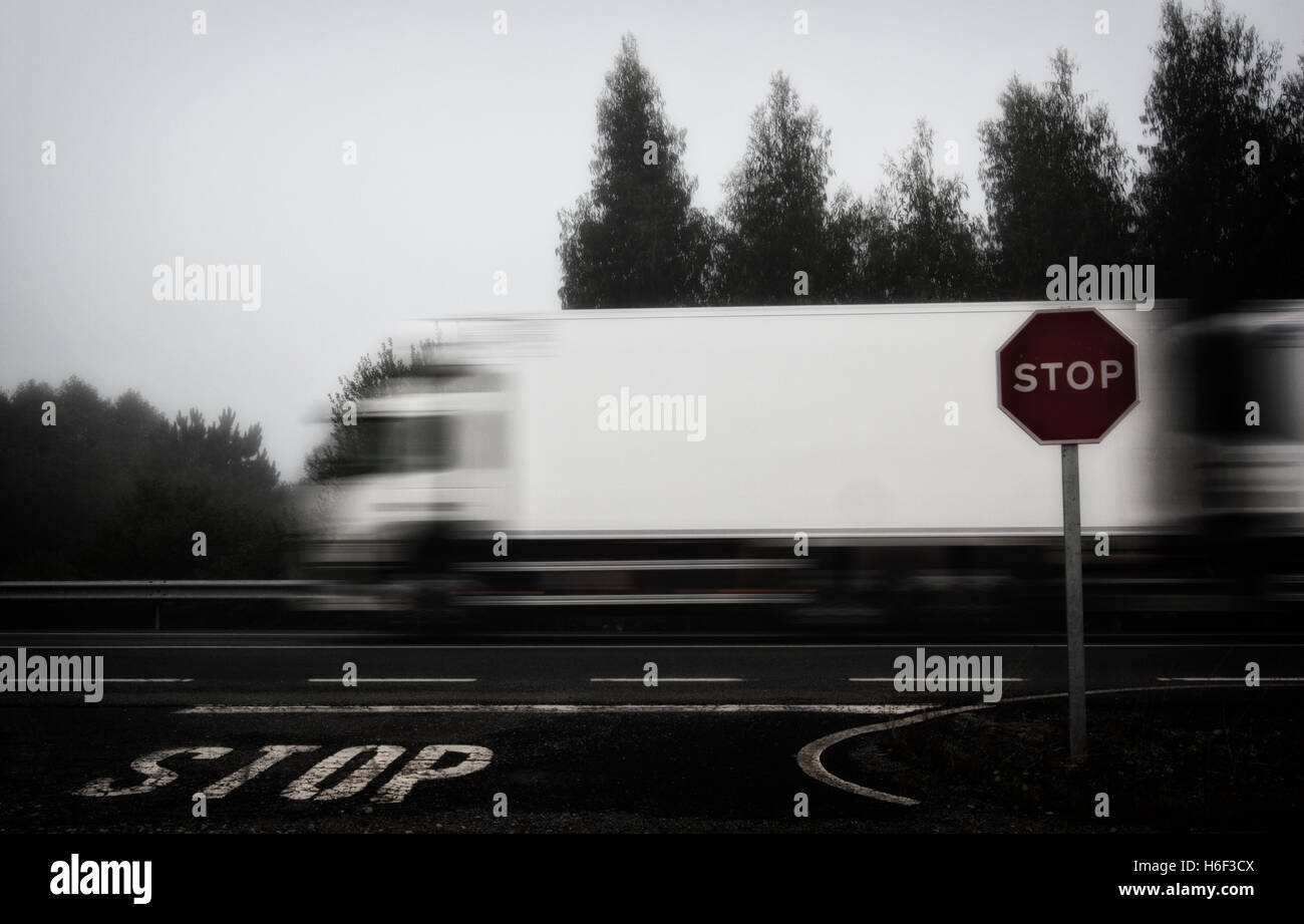 Foto von LKW, die Beschleunigung auf Straße, Stop-Schild und Stop Buchstaben gemalt in den Boden Stockfoto