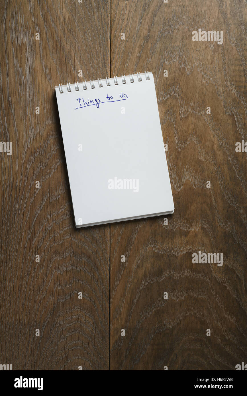 Dinge auf Notizblock auf Holztisch Aufgabenliste Stockfoto