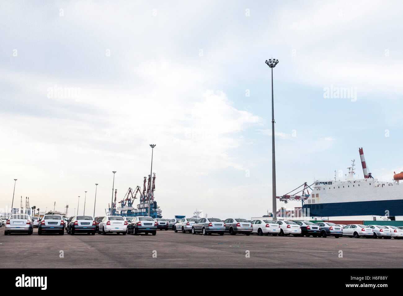 Der Parkplatz ist voll mit neuen Autos, die nur aus dem Auto-Frachter zu ihren Ankunftshafen entladen gewesen. Stockfoto