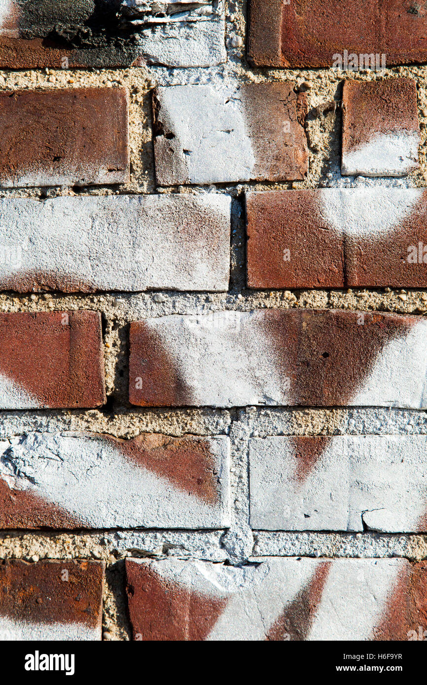 Abstraktion von Brownstone Ziegelwand mit weißen Graffiti drauf. Stockfoto