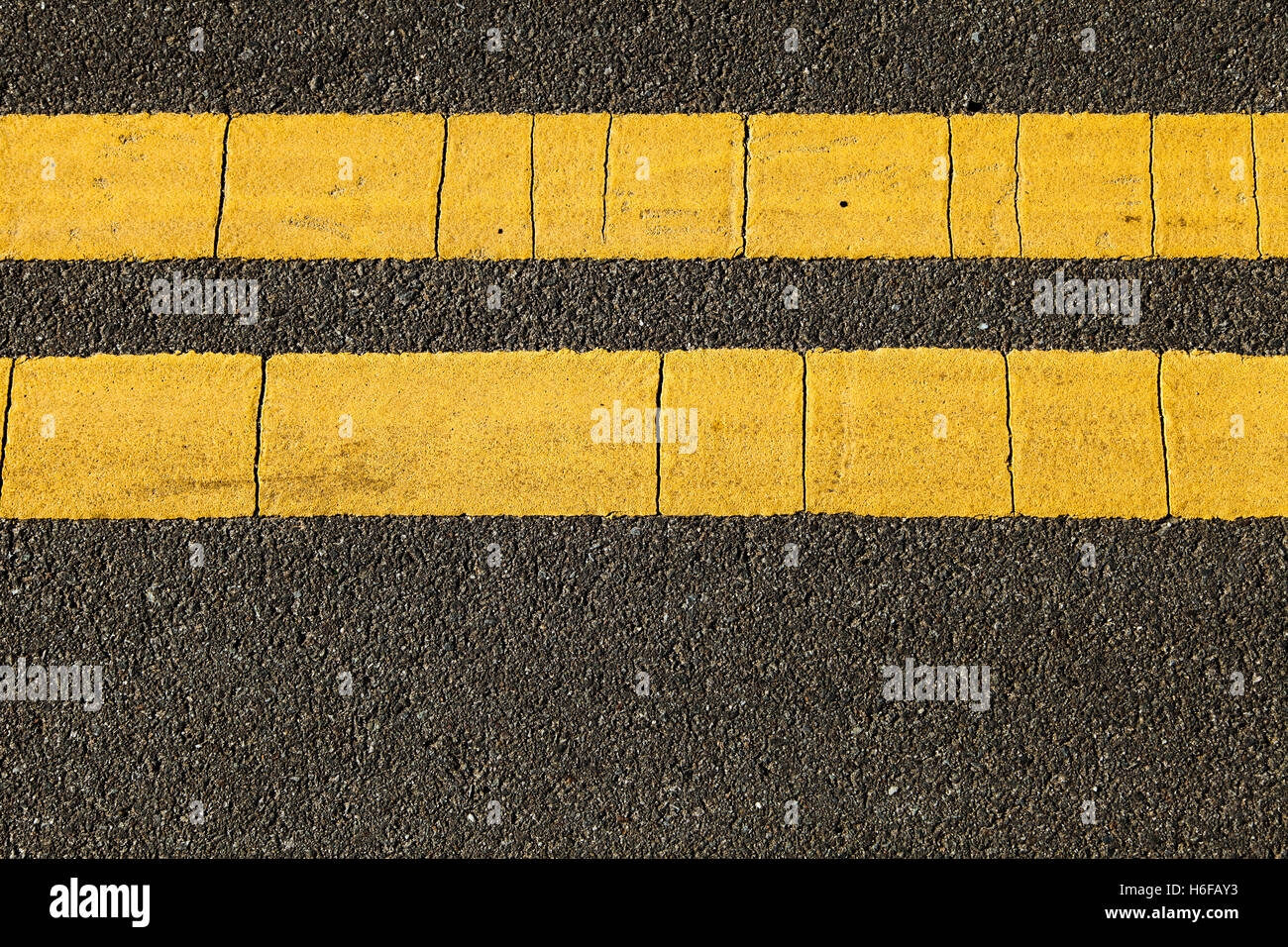 Detailansicht der Asphaltstraße mit gelben Linie Markierungen drauf. Stockfoto