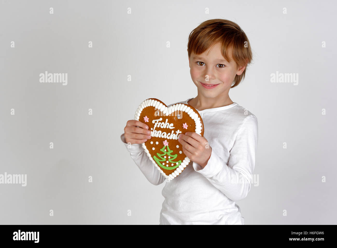 Kind, junge mit Lebkuchenherz, Frohe Wohnaccesoires, Frohe Weihnachten, Upper Bavaria, Bavaria, Germany Stockfoto
