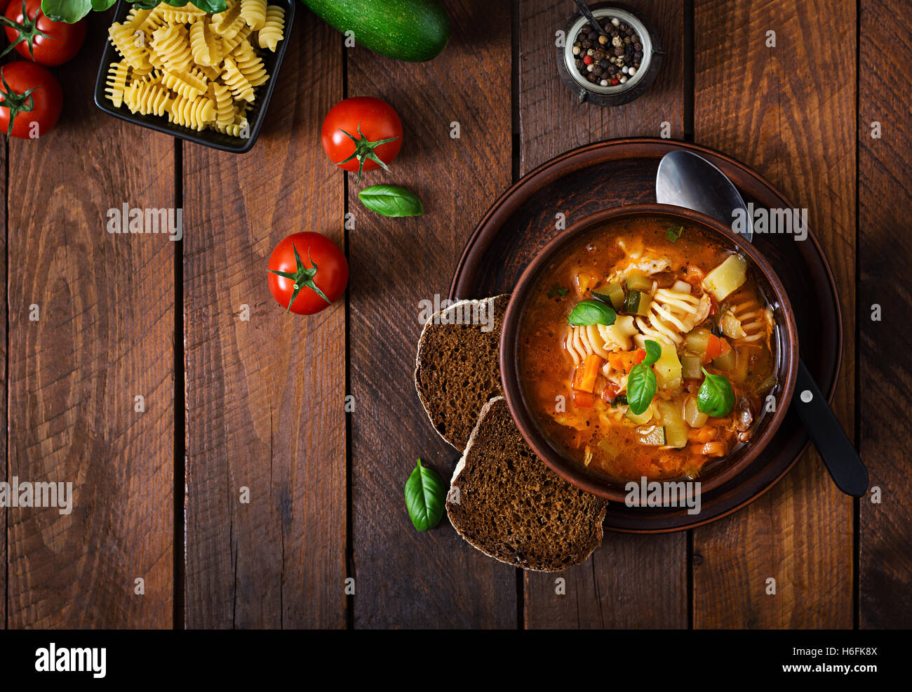 Minestrone, italienische Gemüsesuppe mit Pasta auf Holztisch. Ansicht von oben Stockfoto