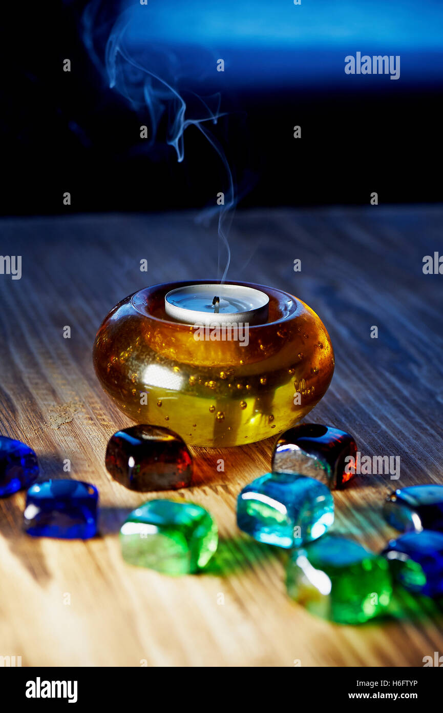 Kerze in Glas orange-Kerze-Halter mit bunten Perlen, Seduta. Rauch steigt Stockfoto Kerze in Glas orange-Kerze-Halter mit bunten Perlen, Seduta. Rauch steigt Stockfoto