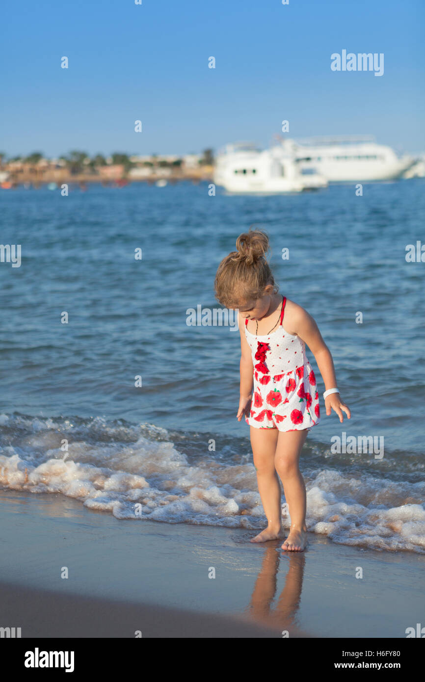 hübsche junge Mädchen spielen in den Wellen des Meeres Stockfoto
