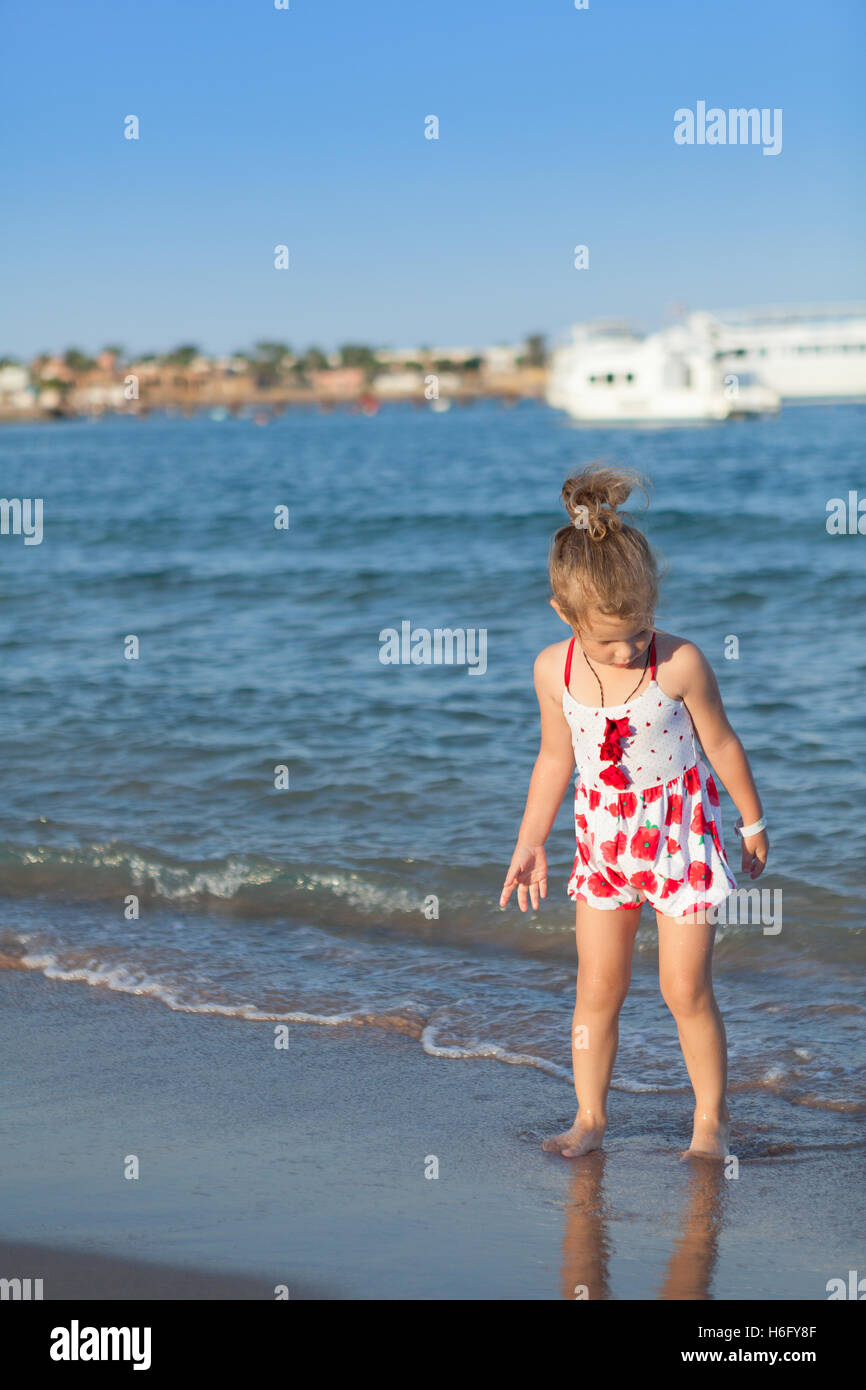 hübsche junge Mädchen spielen in den Wellen des Meeres Stockfoto