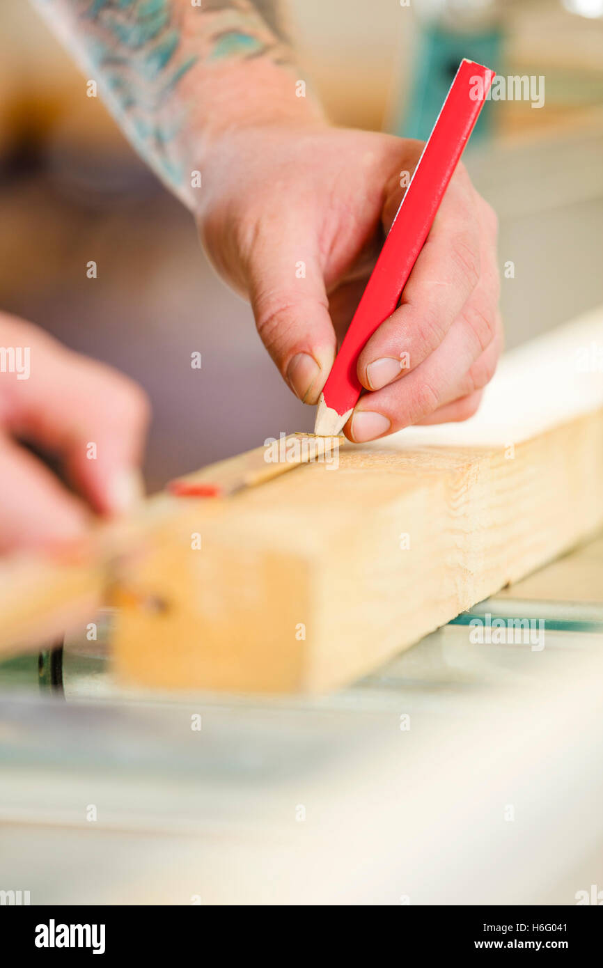 Tischler misst die Länge von einem Holzbrett vor dem Sägen Stockfoto